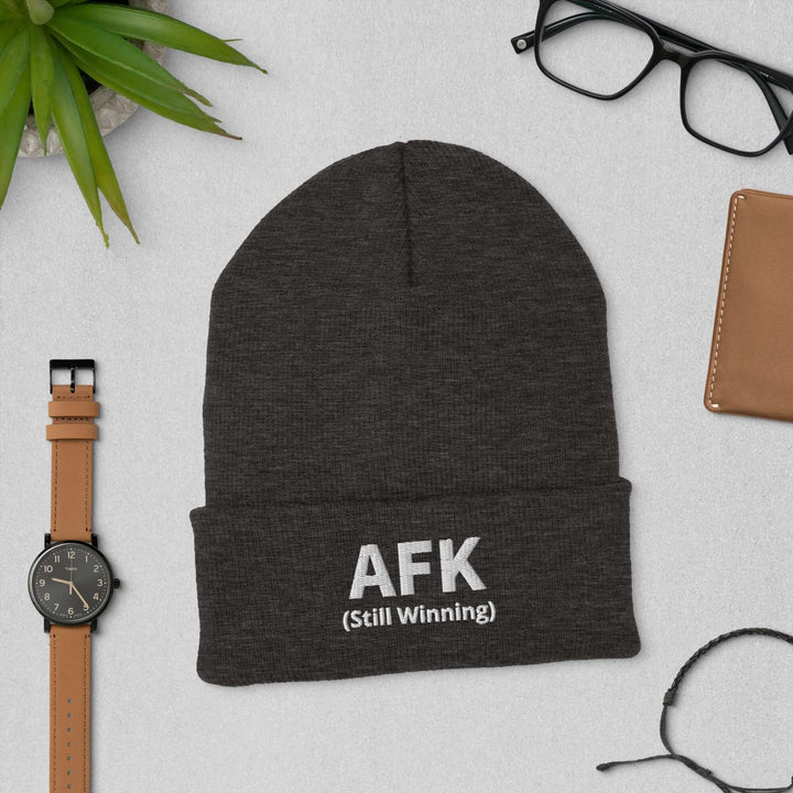 AFK cuffed beanie displayed with accessories on a gray background, showcasing its stylish design and warmth.